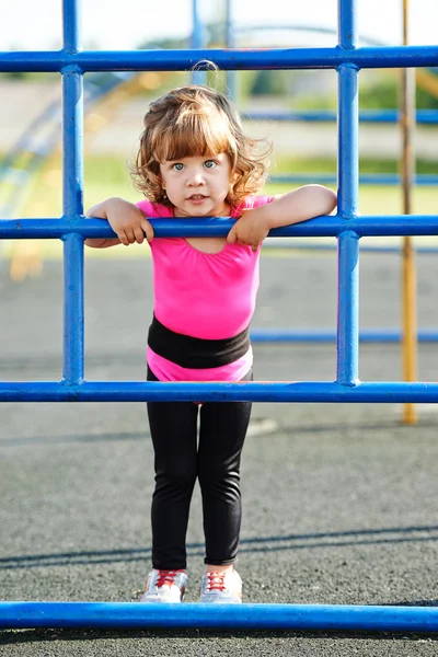 Niedliche kleine Mädchen spielt auf Spielplatz可爱的小女孩在操场上踢 — 图库照片