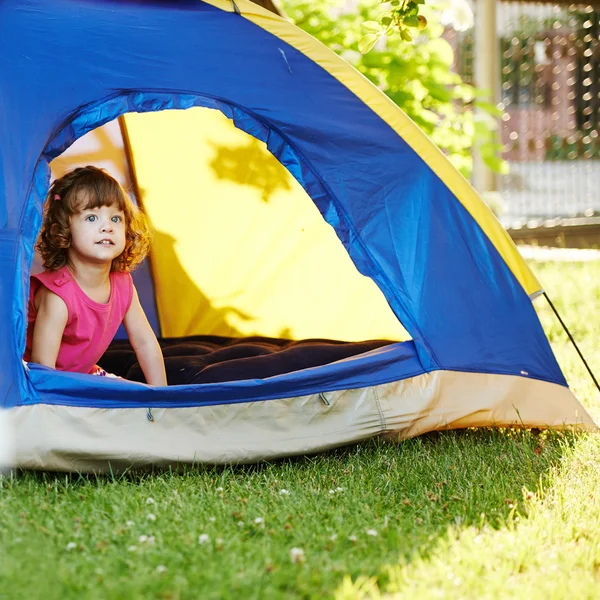 Kleines schönes Mädchen sitzt im Zelt — Stockfoto