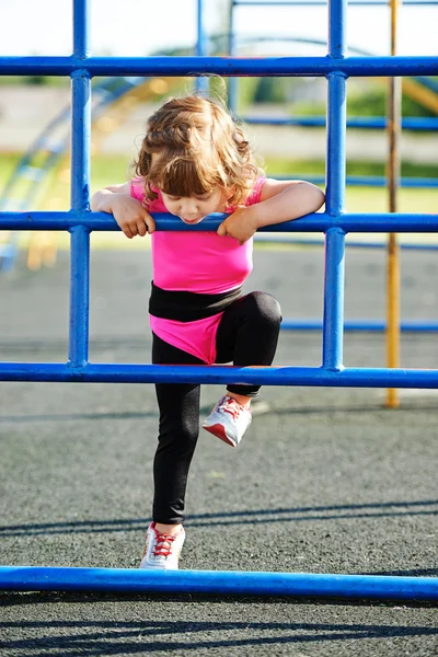 Carino bambina gioca su parco giochi — Foto Stock