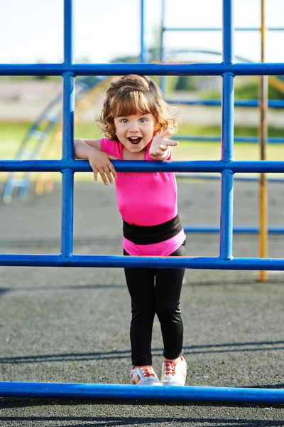 Carino bambina gioca su parco giochi — Foto Stock