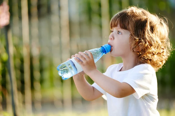 Küçük kız temiz su şişesinden içiyor — Stok fotoğraf