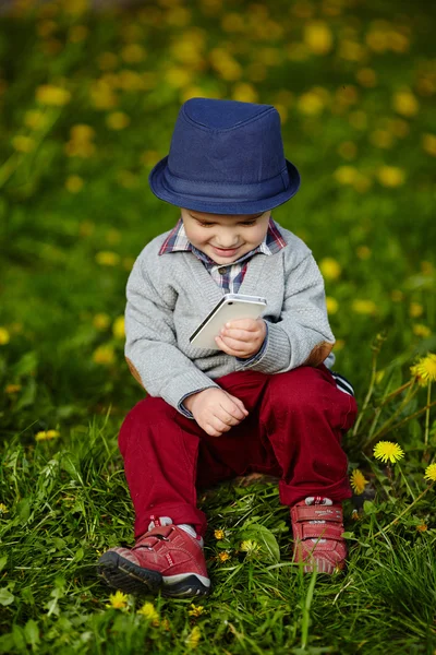 Pequeño chico moderno con teléfono móvil — Foto de Stock