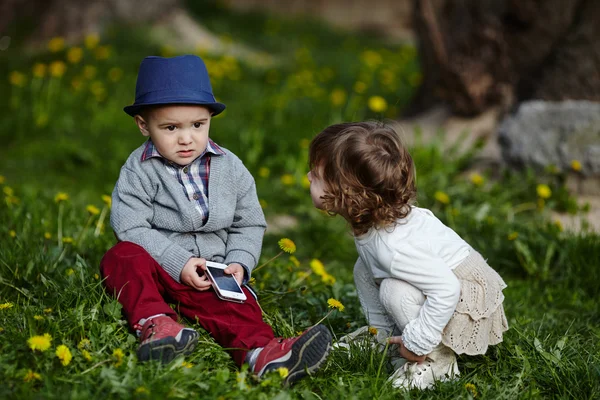 Jongen en meisje spelen met mobiele telefoon — Stockfoto