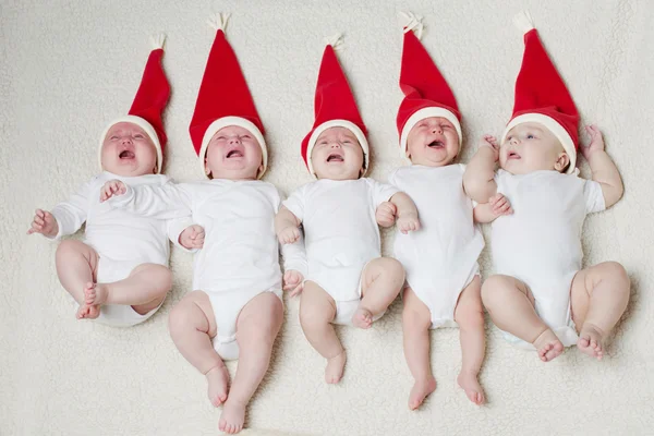 Noel Baba şapkaları parlak zemin üzerine bebeklerle — Stok fotoğraf