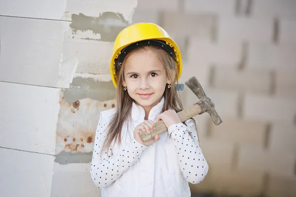 Liten flicka med hjälm arbetar med konstruktion — Stockfoto