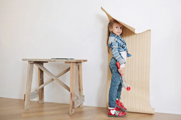 Cute little girl hanging wallpaper — Stock Image Cute little girl hanging wallpaper Stock Image