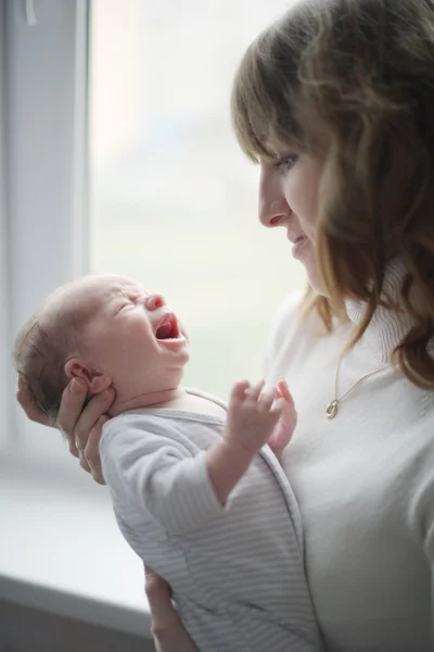Junge Mutter mit weinendem Baby — Stockfoto