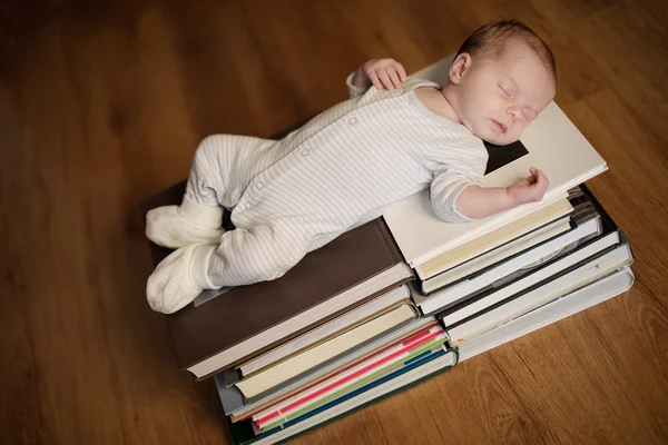 Barnet sover på trave böcker — Stockfoto