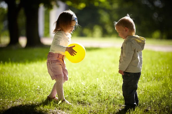 少年と少女は、黄色のボールで遊んで — ストック写真