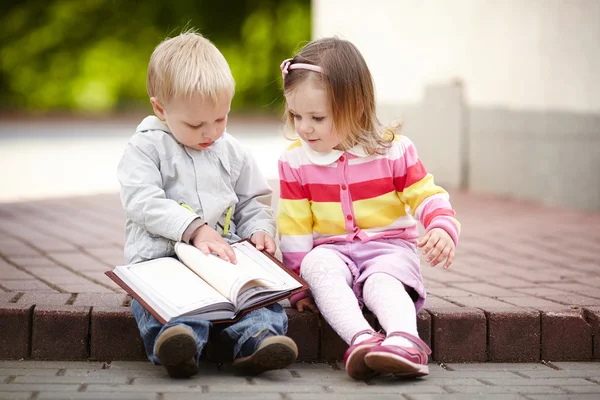 Funny boy and girl reading book — Stock Photo, Image