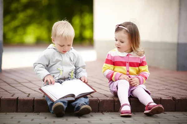 Divertido chico y chica leyendo libro Imagen de stock