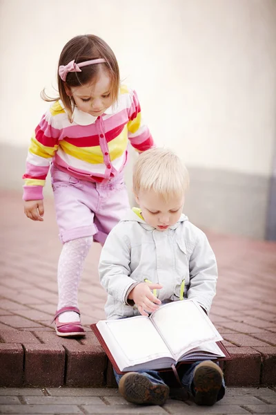 Niño y niña leyendo un libro Imágenes de stock libres de derechos