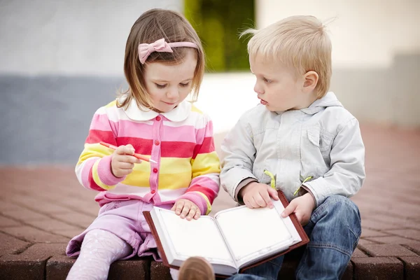 Niño y niña escribiendo a cuaderno —  Fotos de Stock
