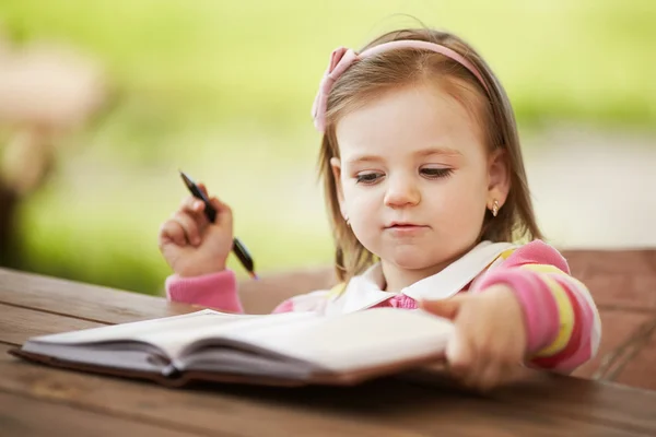 Söt liten flicka lära sig att skriva — Stockfoto
