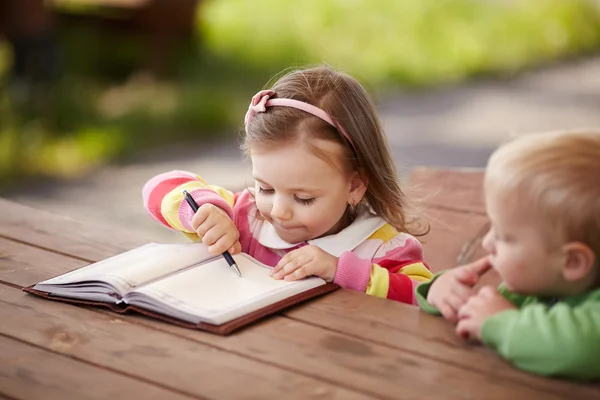 Kleine jongen en meisje leren schrijven — Stockfoto