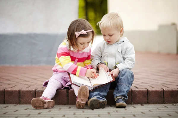 Niño y niña escribiendo a cuaderno Fotos de stock libres de derechos