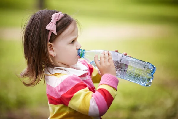 Klein meisje mineraal water drinkt — Stockfoto