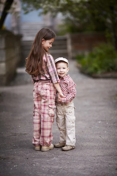 Niño abrazando linda hermana y mira hacia arriba — Foto de Stock