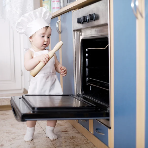 Babyköchin kocht im Ofen Essen — Stockfoto