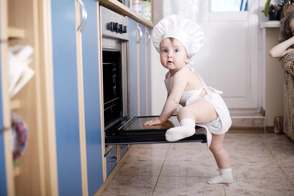 Baby kuchař vaří v troubě potraviny — Stock fotografie