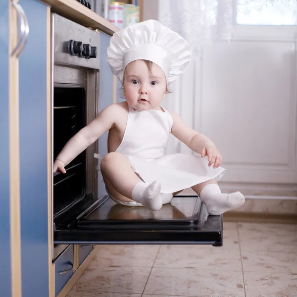 Baby kuchař vaří v troubě potraviny — Stock fotografie