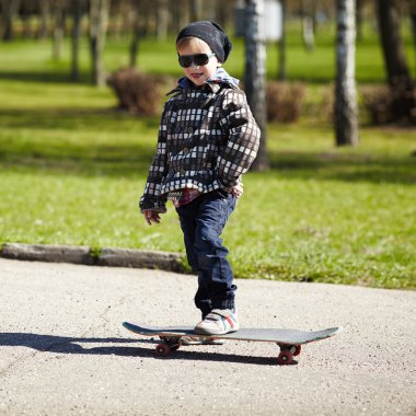 küçük çocuk sokakta kaykay ile