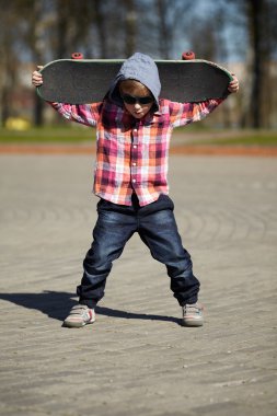 küçük çocuk sokakta kaykay ile