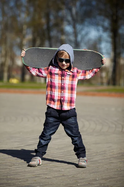 Niño pequeño con monopatín en la calle — Foto de Stock