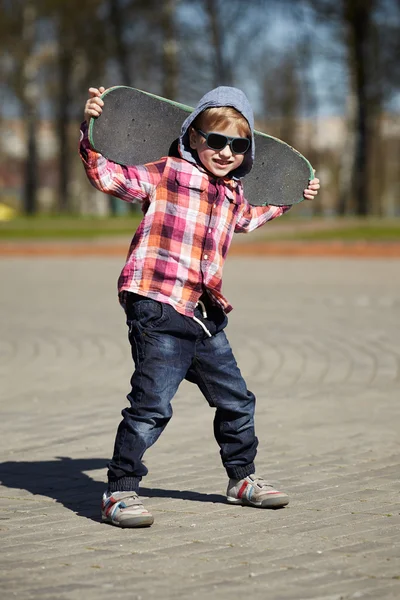 Niño pequeño con monopatín en la calle — Foto de Stock