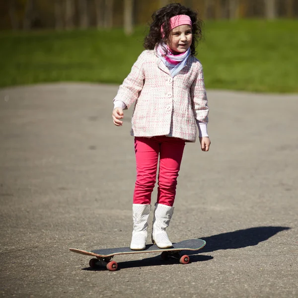 Klein meisje schaatsen op de straat — Stockfoto