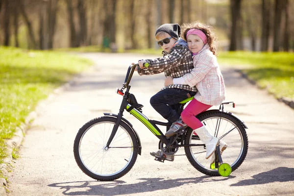 Девочка и мальчик на велосипеде — стоковое фото