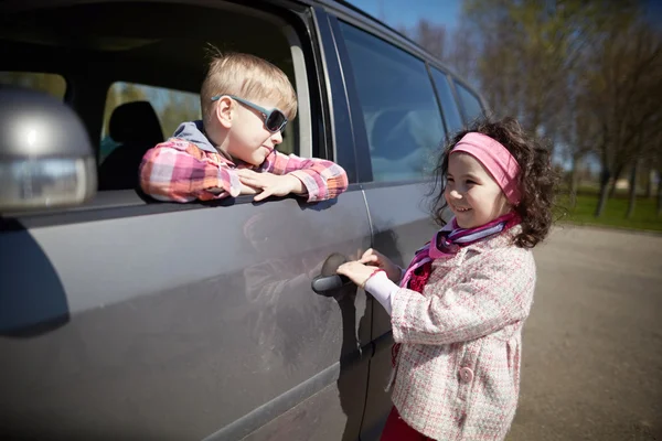 Menina e menino de condução pais carro — Fotografia de Stock