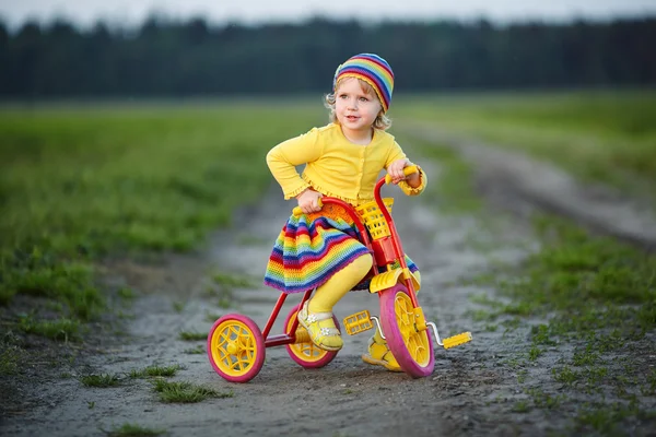 Κορίτσι με πολύχρωμο φόρεμα στο ποδήλατο — Φωτογραφία Αρχείου