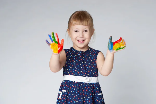 Menina com as mãos na pintura no branco — Fotografia de Stock