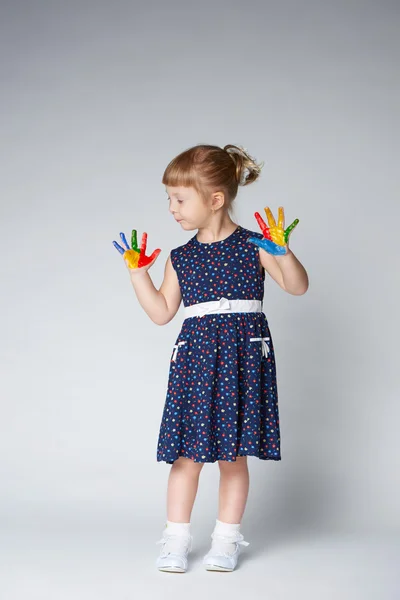 Menina com as mãos na pintura no branco — Fotografia de Stock