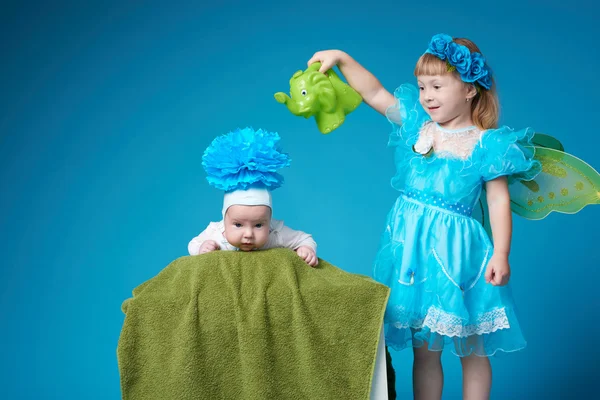 Girl waters her younger brother — Stock Photo, Image