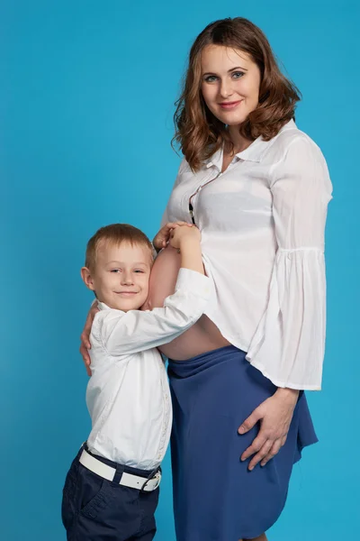 Молодой мальчик обнимает беременную мать — стоковое фото