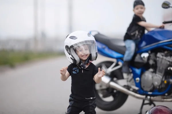Маленькие байкеры на дороге с мотоциклом — стоковое фото
