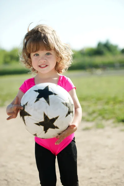 Gadis kecil bermain sepak bola di stadion — Stok Foto