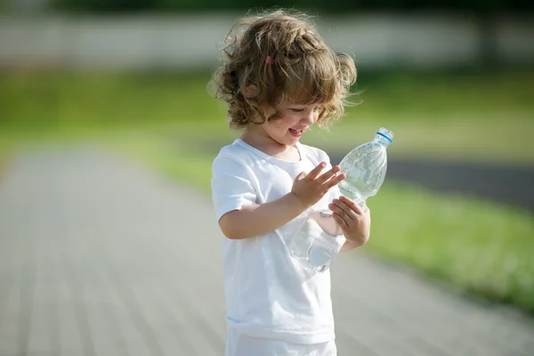 Bambina che beve acqua pulita dalla bottiglia di plastica — Foto Stock