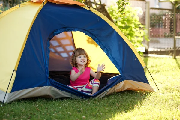 Kleines Mädchen sitzt im bunten Zelt — Stockfoto