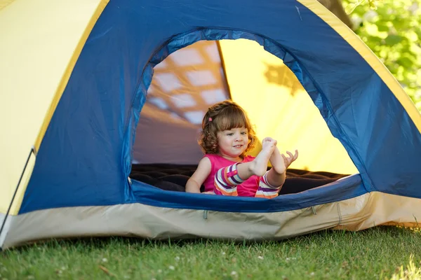 Menina sentada na tenda colorida — Fotografia de Stock