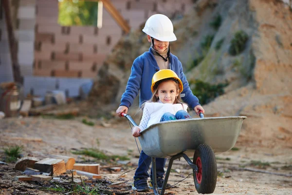 Boy and girl playing on construction site — Stock Photo, Image