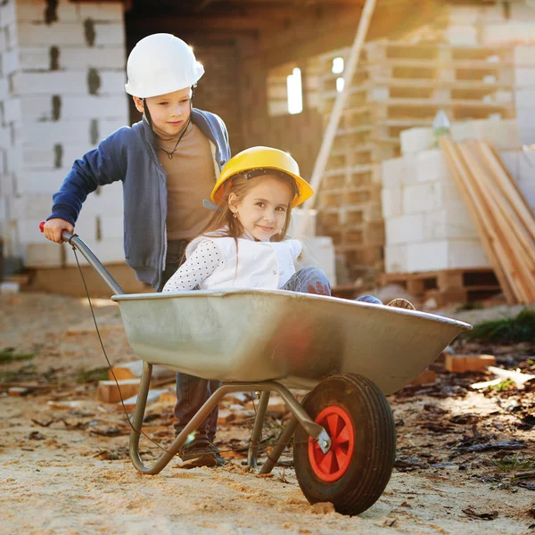 Niño y niña jugando en el sitio de construcción — Foto de Stock