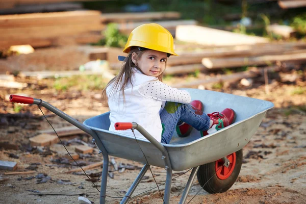 Girl riding in the construction wheelbarrow — Stock Photo, Image