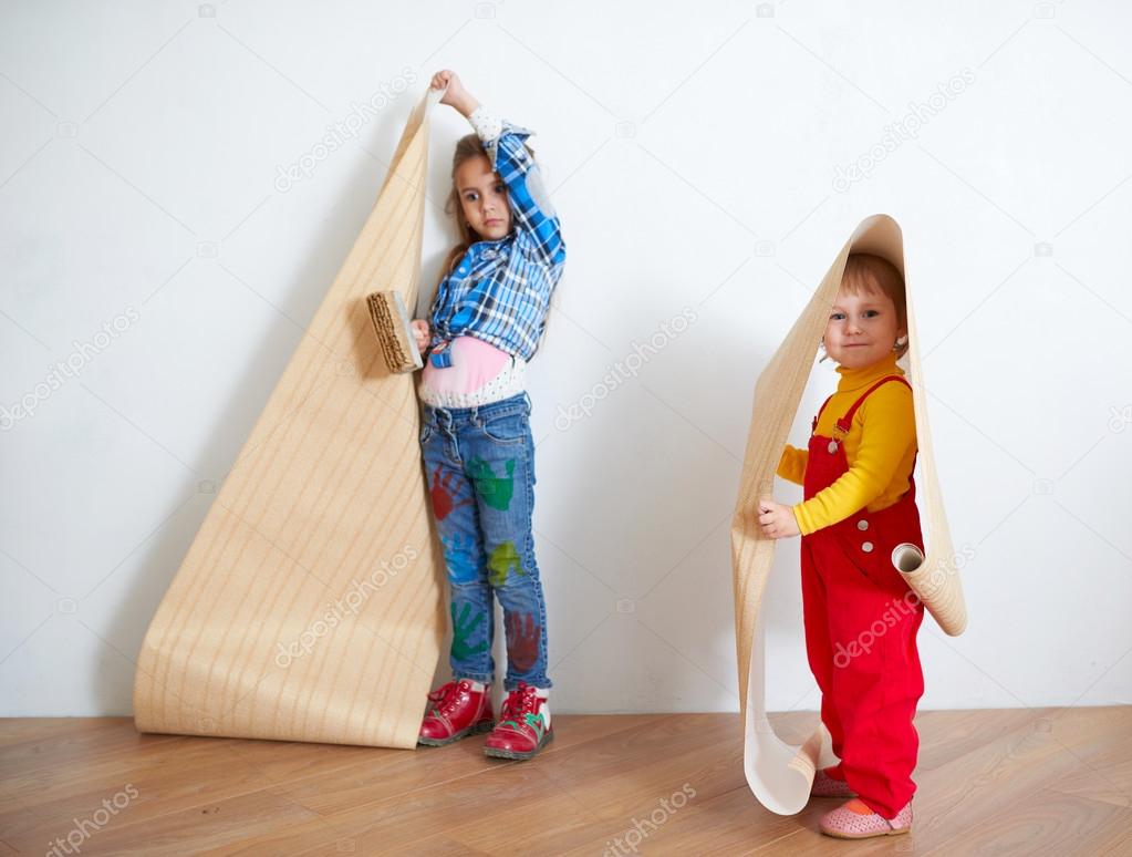 Girls hanging wallpaper. Decorating the wall Stock Photo by ©ababaka  64074029