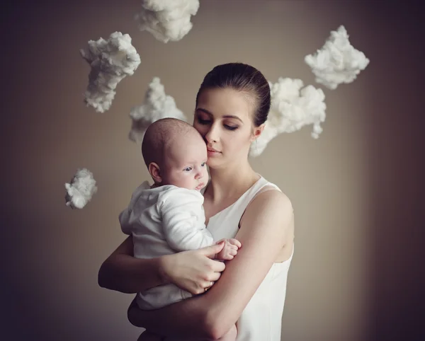 Mother with baby on white clouds — Stock Photo, Image