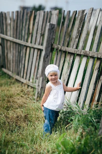 Petite fille et clôture en bois — Photo