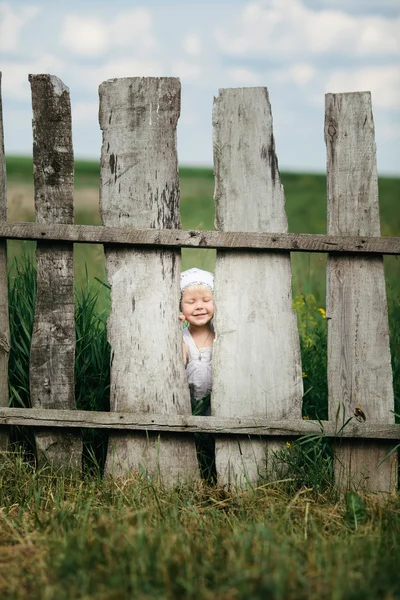 Menina e cerca de madeira — Fotografia de Stock