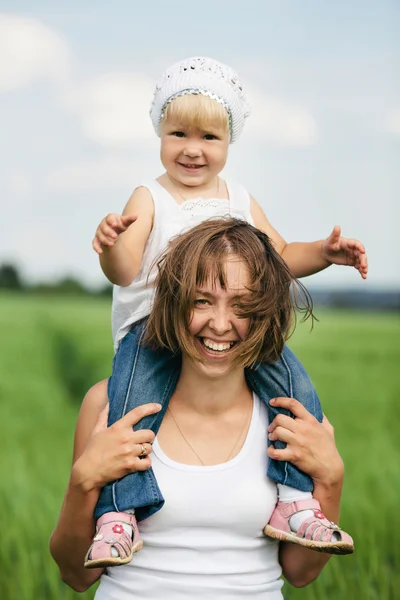 Glad mamma med dotter i fältet — Stockfoto